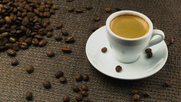 Una tazza di espresso, una manciata di chicchi di caffè — Video Stock