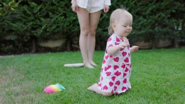 Küçük kız hızla dizlerinin üzerinde yeşil çimlerde sürünüyor..