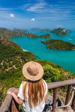 Ang Tanga Ulusal Deniz Parkı 'nda tropik adalara ve turkuaz denize bakan genç bir kadın. Yüksek kalite fotoğraf