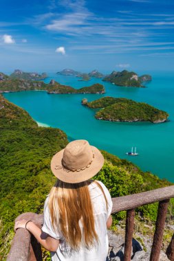 Ang Tanga Ulusal Deniz Parkı 'nda tropik adalara ve turkuaz denize bakan genç bir kadın. Yüksek kalite fotoğraf