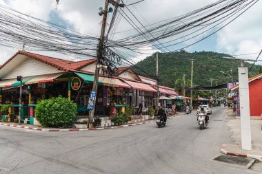 Ko Samui, Tayland, 16 Mart 2026: Lamai köyü Koh Samui Tayland 'da dükkanları, scooterları ve elektrik hatları olan cadde.