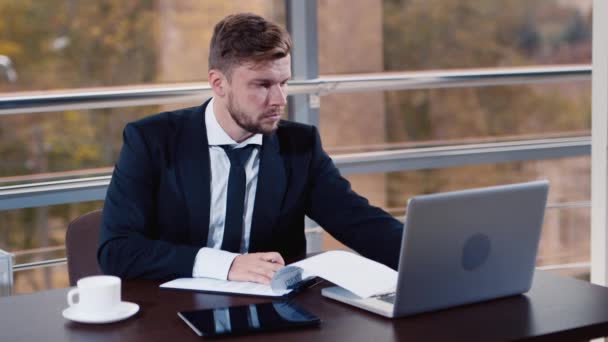 Empresario trabajando en una laptop en la oficina — Vídeos de Stock