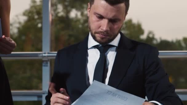 Un homme d'affaires signe un certain nombre de documents — Video