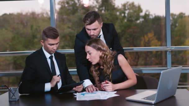 Happy business people gathered around laptop looking at camera in the office — Stock Video