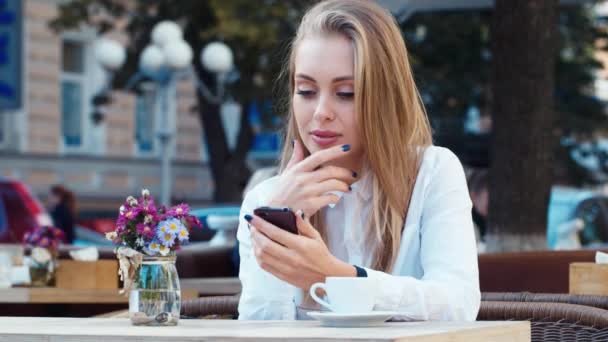 Mujer de negocios en un café escribiendo sms — Vídeos de Stock