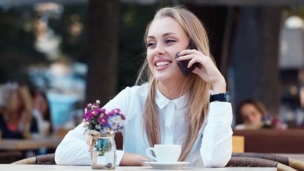 Деловая женщина в кафе разговаривает по мобильному телефону — стоковое видео