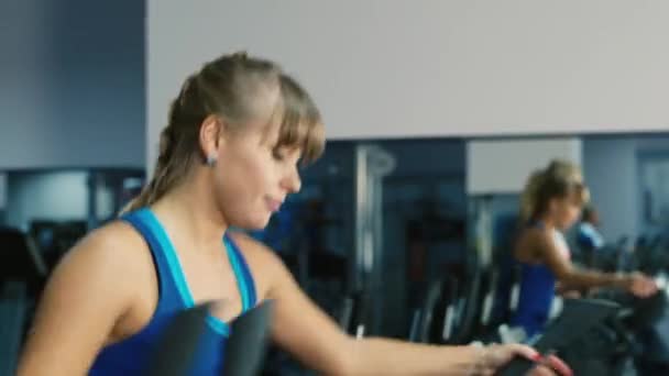 Mujer atractiva entrenada en el gimnasio sonriendo — Vídeos de Stock