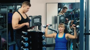 Çekici kadın spor salonunda kişisel bir eğitmen ile eğitimli.