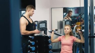 Çekici kadın spor salonunda kişisel bir eğitmen ile eğitimli.