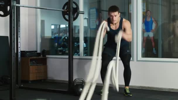 Чоловік робить вправи на мотузці в спортзалі — стокове відео