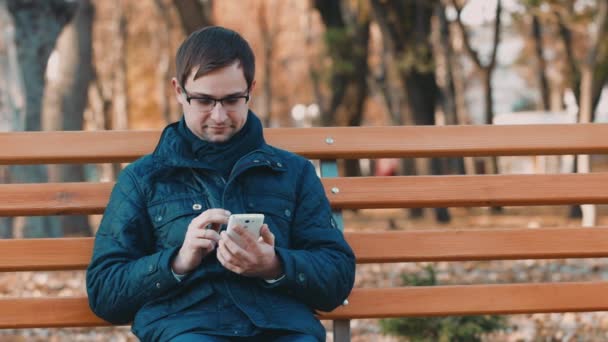 Genç bir adam bir smartphone ile çalışma — Stok video