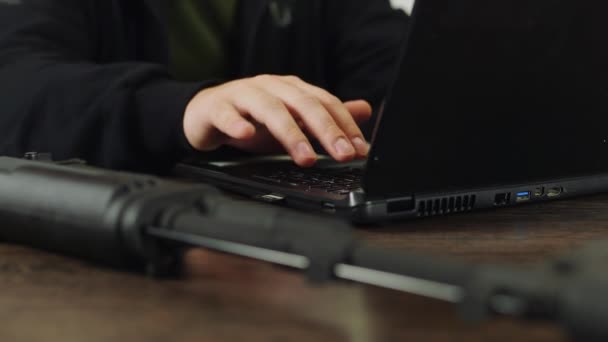 En vapenhandlare på jobbet, arbetar med en bärbar dator — Stockvideo