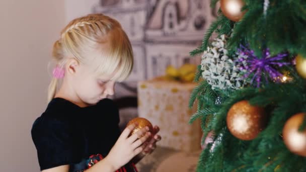 Petite fille décore le sapin de Noël 