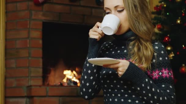 Kvinnan dricka te vid brasan — Stockvideo