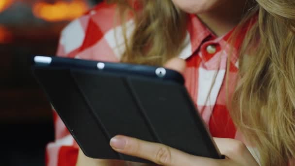 Vrouw met Tablet PC in de buurt van de open haard — Stockvideo
