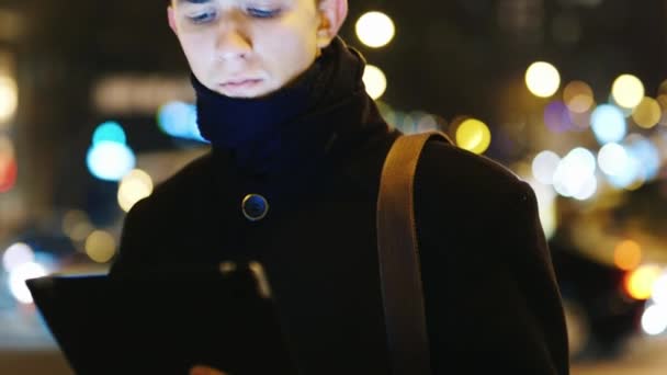 De jonge man met de Tablet PC tegen de avond stad — Stockvideo