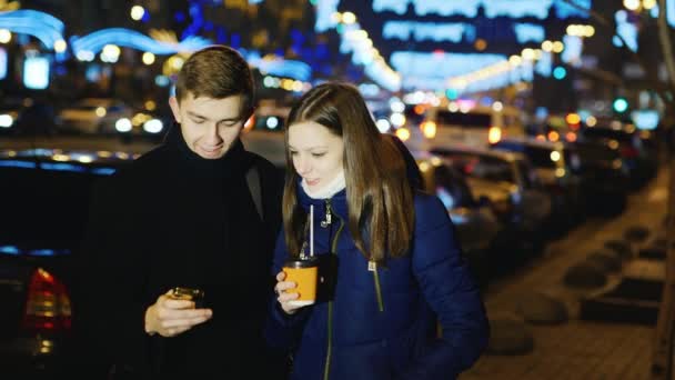 Молодой человек и женщина разговаривают в ночном городе — стоковое видео