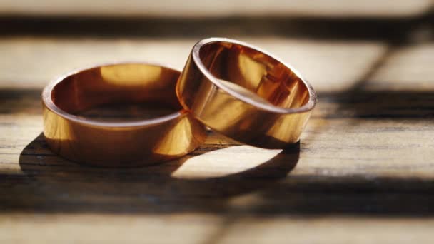 Wedding rings on a wooden texture — Stock Video