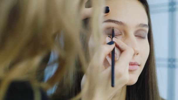 Mladá dívka aplikovat make-up kolem očí — Stock video