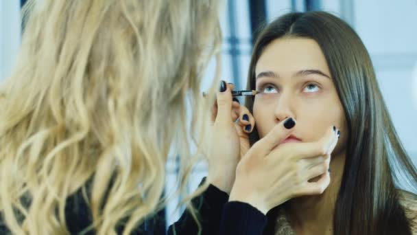 A young girl apply makeup around the eyes — Stock Video