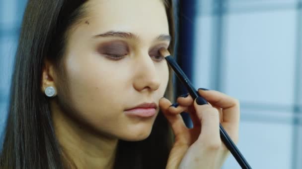 Mujer joven aplicar maquillaje alrededor de los ojos — Vídeo de stock