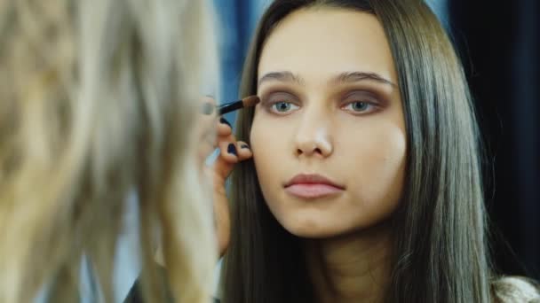 Young woman apply makeup around the eyes — Stock Video