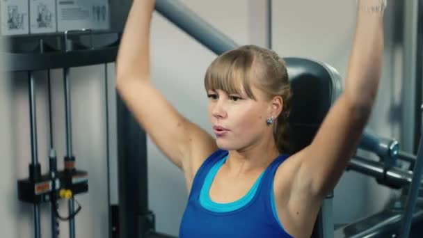 Une jolie femme s'entraîne sur un appareil de fitness — Video