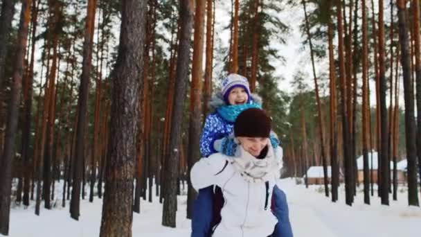 Mamá juega con su hija en un parque de invierno — Vídeos de Stock