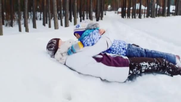 Jonge moeder speelt met haar dochter in de sneeuw — Stockvideo