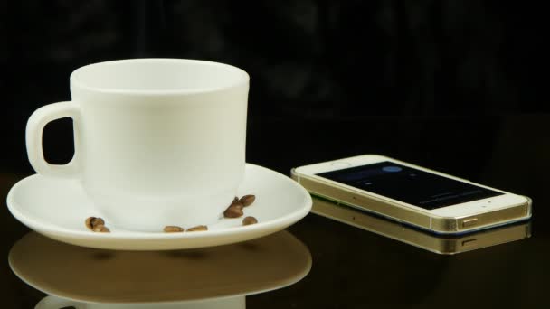 Kopje koffie en mobiele telefoon — Stockvideo
