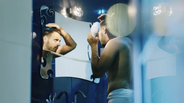 매력적인 젊은 남자는 거울에 머리를 건조 — 비디오