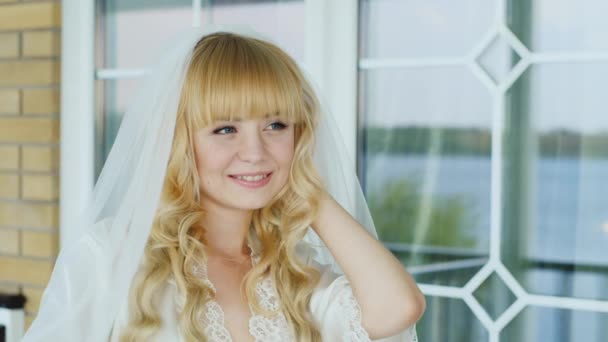 Портрет молодої блондинки - посміхаючись, дивлячись на відстань — стокове відео