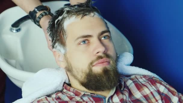 Чоловік миє волосся — стокове відео