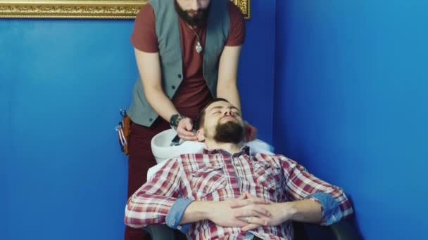 Jeune homme barbu se laver la tête dans les salons de coiffure — Video