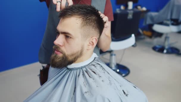 Barbeiro corta o cabelo do cliente com tesoura — Vídeo de Stock