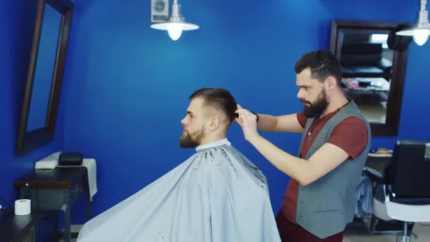 Barbiere taglia i capelli del cliente con le forbici — Video Stock