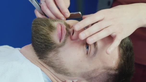 Penteado masculino e corte de cabelo em uma barbearia ou salão de cabeleireiro. Arrumar a barba — Vídeo de Stock