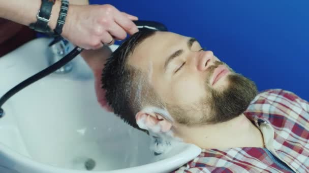 Man Kapper wassen mannelijke haar in een Barbershop — Stockvideo