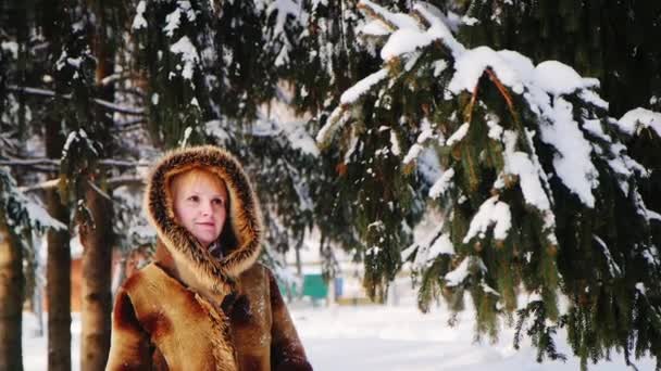 Зимові забави: жінка трясе дерево, сміється — стокове відео