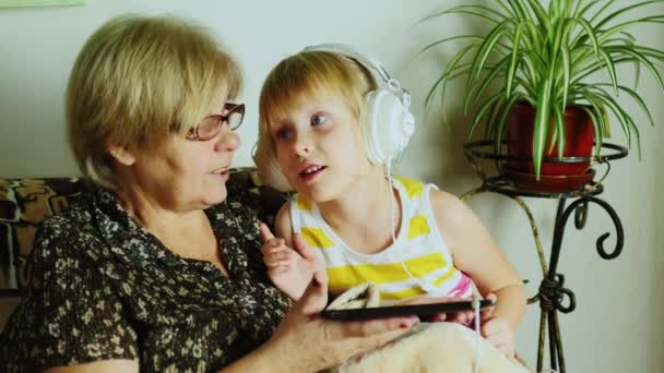 Mormor leker med hans barnbarn på tabletten — Stockvideo