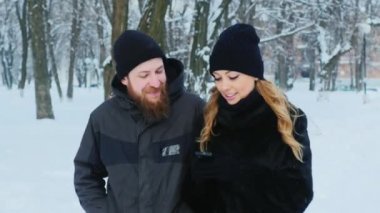 Smartphone kullanarak parkta yürüyen bir çekici çift