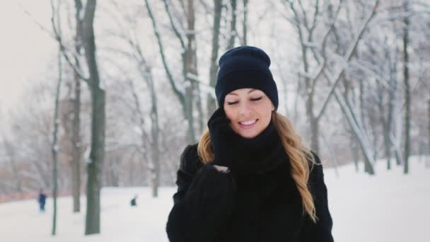 Jonge vrouw spreekt op de telefoon in winter park — Stockvideo