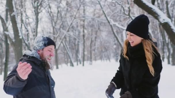 Barbudo hombre y mujer divirtiéndose en el bosque de invierno — Vídeos de Stock