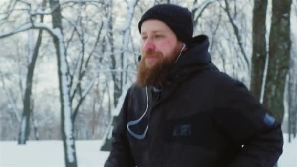 Bebaarde man joggen in het park van de winter — Stockvideo