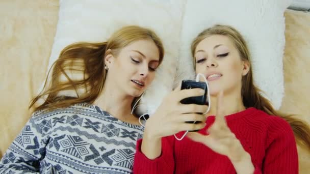 Zwei attraktive Mädchen kommunizieren mit Freunden per Telefon — Stockvideo