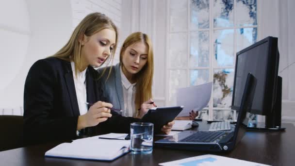 Twee vrouwen die werken met de gadgets binnenshuis — Stockvideo