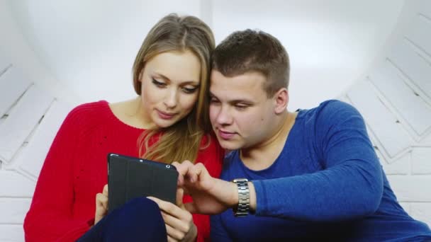 Joven hombre y mujer usando una tableta — Vídeo de stock