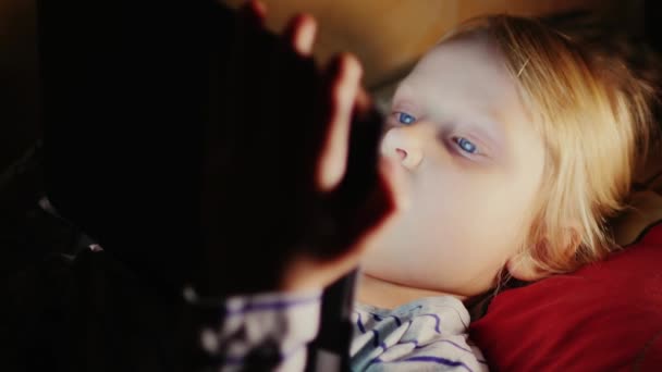Dívka ležela na posteli, pomocí tablet — Stock video