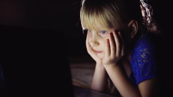 A criança de olhos azuis olhando para a tela do laptop — Vídeo de Stock