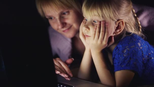 Mor och dotter spelar på den bärbara datorn innan du går till sängs — Stockvideo